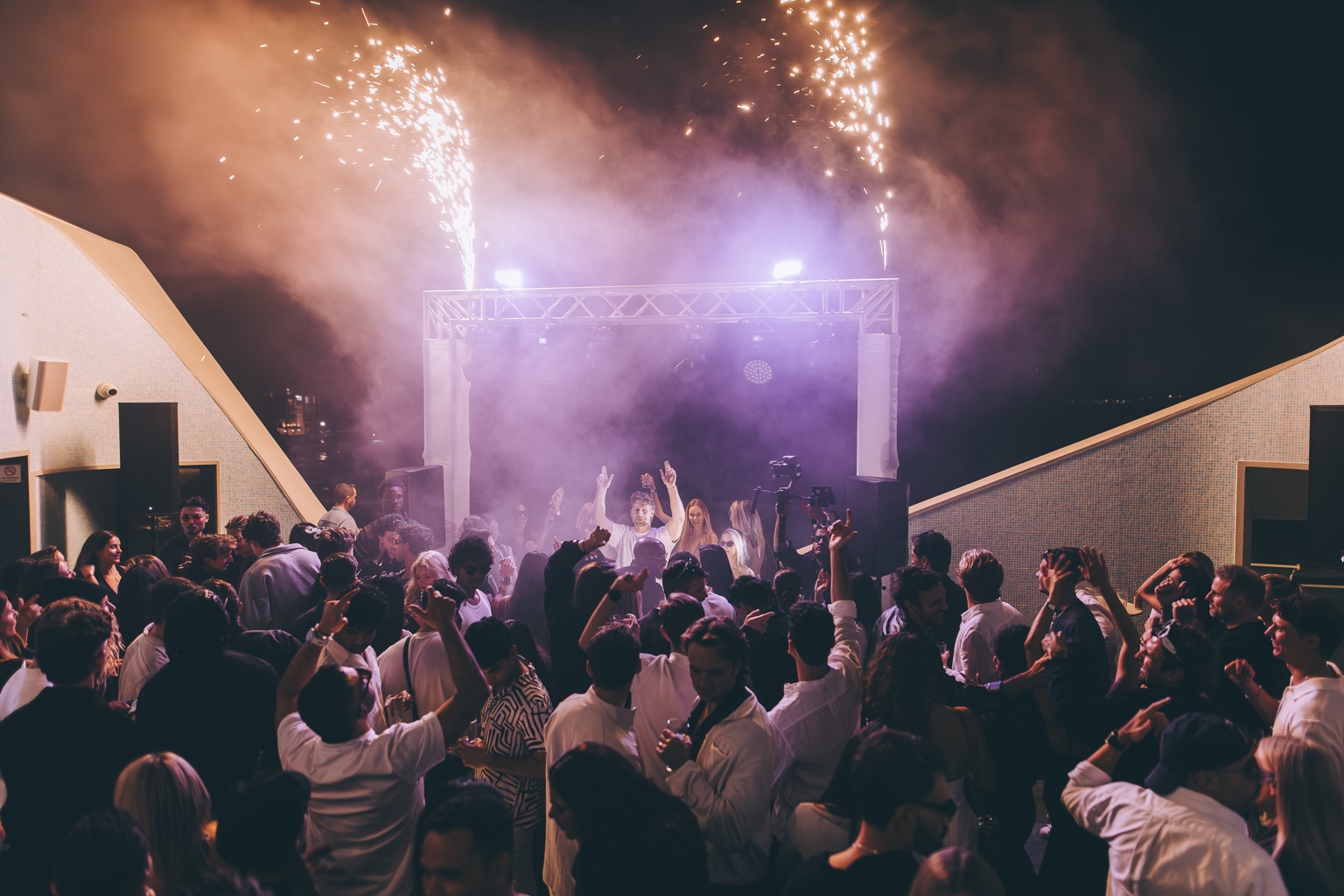 Veluna crowd dancing beneath the night-time stage sparks
